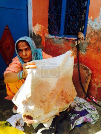 Photo for INDIA, Dadri: Asgara Begum, age 70, holds the blood soaked shirt that her son Mohammad Ikhlaq, age 52, was wearing when he was killed by a mob over rumors that the family had been storing and consuming beef at their home in Dadri, Uttar Pradesh - Royalty Free Image