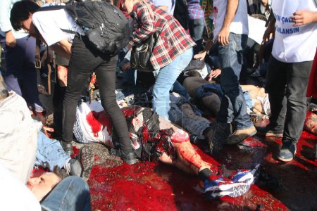 Foto de TURQUÍA, Ankara: La gente trata de ayudar a las víctimas heridas de un ataque terrorista que mató al menos a 30 personas en Ankara, capital de Turquía, el 10 de octubre de 2015. - Imagen libre de derechos