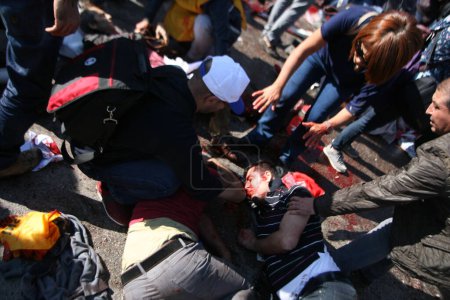 Téléchargez les photos : TURQUIE, Ankara : Les gens tentent d'aider les victimes blessées d'un attentat terroriste qui a tué au moins 30 personnes à Ankara, capitale de la Turquie, le 10 octobre 2015. - en image libre de droit