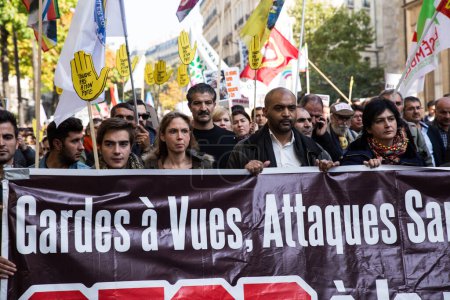 Foto de FRANCIA, París: Manifestantes sostienen una pancarta y carteles de la asociación antirracista francesa 'SOS Racisme' durante una manifestación organizada por el Consejo Democrático Kurdo de Francia en París, el 11 de octubre de 2015 - Imagen libre de derechos