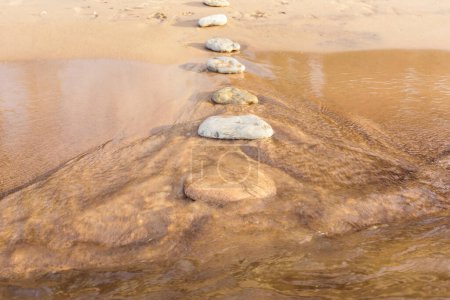 Téléchargez les photos : Chemin de pierres sur une plage de sable fin - en image libre de droit