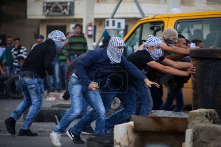 Téléchargez les photos : BANQUE DE L'OUEST, Ramallah : De jeunes Palestiniens masqués sont vus dans une rue du nord de Ramallah, en Cisjordanie, le 9 octobre 2015 - en image libre de droit