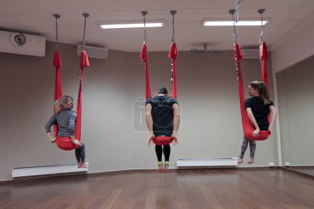 Photo for Women with man doing anti-gravity yoga - Royalty Free Image
