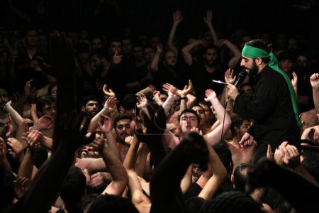 Foto de IRÁN, Teherán: Cientos de musulmanes chiítas sin camisa en el complejo Reyhane-Al-Hossein asisten a la sesión de duelo en homenaje al imán Husayn ibn Ali el 21 de octubre de 2015, la octava noche de Muharram en Teherán, Irán. - Imagen libre de derechos