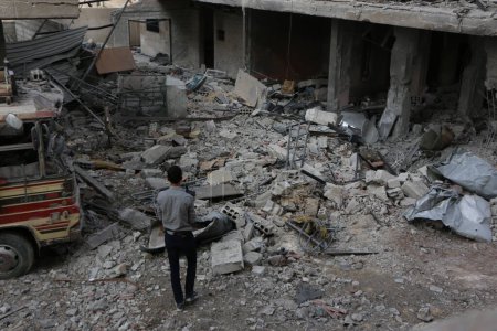 Téléchargez les photos : SYRIE, Damas : Un Syrien regarde des bâtiments endommagés dans le quartier de Marj al-Sultan à l'est de Damas le 24 octobre 2015. - en image libre de droit