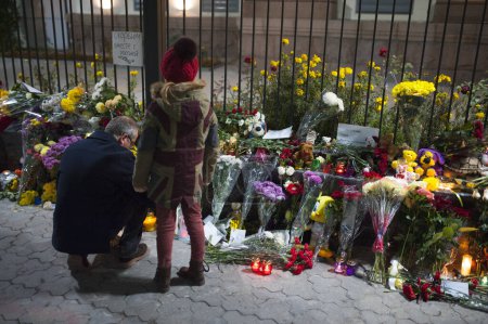 Foto de UCRANIA, Kiev: Un hombre pone flores fuera de la embajada rusa en Kiev, Ucrania, para rendir homenaje a las víctimas de un avión Metrojet ruso estrellado en Egipto, el 1 de noviembre de 2015. - Imagen libre de derechos