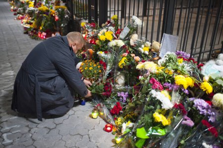 Foto de UCRANIA, Kiev: Un hombre pone flores fuera de la embajada rusa en Kiev, Ucrania, para rendir homenaje a las víctimas de un avión Metrojet ruso estrellado en Egipto, el 1 de noviembre de 2015. - Imagen libre de derechos
