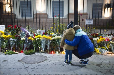 Foto de UCRANIA, Kiev: Una mujer y su hijo son fotografiados fuera de la embajada rusa en Kiev, Ucrania, para rendir homenaje a las víctimas de un avión Metrojet ruso estrellado en Egipto, el 1 de noviembre de 2015 - Imagen libre de derechos