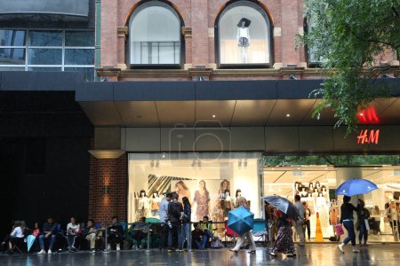 Foto de AUSTRALIA, Sydney: Una cola se forma fuera de la tienda H & M en Pitt Street Mall, Sydney el 4 de noviembre de 2015 antes del lanzamiento oficial de la gama de moda Balmain X H & M el 5 de noviembre de 2015. - Imagen libre de derechos
