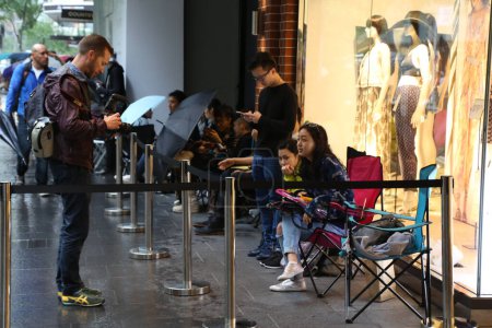 Photo for AUSTRALIA, Sydney: A queue forms outside the H&M store in Pitt Street Mall, Sydney on November 4, 2015 ahead of the official launch of the Balmain X H&M fashion range on November 5, 2015. - Royalty Free Image