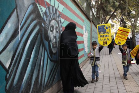 Téléchargez les photos : IRAN, Téhéran : Des garçons arborent des pancartes indiquant "A bas les États-Unis" alors que des centaines de personnes défilent devant l'ancienne ambassade américaine à Téhéran, pendant le '13 Aban' (4 novembre en anglais), le 4 novembre 2015 - en image libre de droit