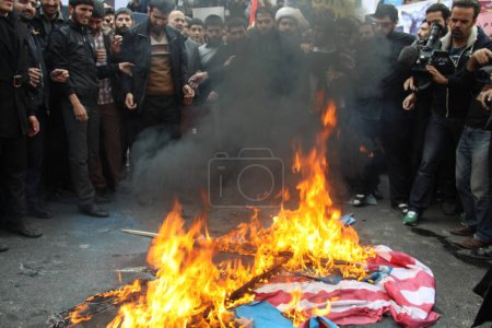 Téléchargez les photos : IRAN, Téhéran : Des manifestants brulent un drapeau américain alors que des centaines de personnes défilent devant l'ancienne ambassade américaine à Téhéran, pendant le '13 Aban' (4 novembre en anglais), le 4 novembre 2015 - en image libre de droit