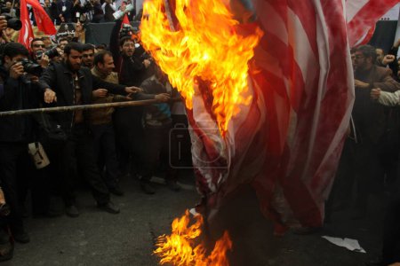 Téléchargez les photos : IRAN, Téhéran : Des manifestants brulent un drapeau américain alors que des centaines de personnes défilent devant l'ancienne ambassade américaine à Téhéran, pendant le '13 Aban' (4 novembre en anglais), le 4 novembre 2015 - en image libre de droit