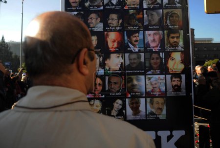 Téléchargez les photos : URKEY, Ankara : Un homme regarde un panneau portant les visages des victimes des attentats du 10 octobre lors d'une cérémonie à Ankara, en Turquie, le 7 novembre 2015, en l'honneur des victimes. - en image libre de droit