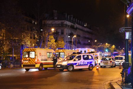 Foto de PARÍS, FRANCIA: Ambulancias y sondeos están aparcados cerca de la sala de conciertos de Bataclan después de un ataque el 13 de noviembre de 2015 en París - Imagen libre de derechos