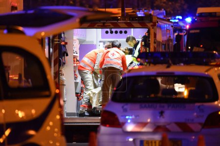 Foto de PARÍS, FRANCIA: Ambulancias y pollice ars están aparcados cerca de la sala de conciertos Bataclan después de un ataque el 13 de noviembre de 2015 en París, Francia. - Imagen libre de derechos