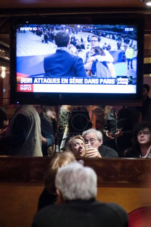 Téléchargez les photos : FRANCE, Paris : Les gens regardent la télévision dans le 11ème arrondissement de Paris après une attaque le 13 novembre 2015 à Paris, France. - en image libre de droit