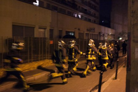 Téléchargez les photos : FRANCE, Paris : Les pompiers se précipitent dans les rues du 3ème arrondissement de Paris après une série de fusillades et d'explosions dans la capitale le 13 novembre 2015. - en image libre de droit