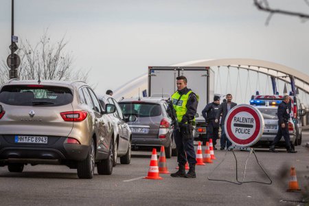 Téléchargez les photos : FRANCE, Strasbourg : Des policiers inspectent des voitures et des véhicules passant le pont Europa au poste frontière franco-allemand entre Kehl et Strasbourg, France, 14 novembre 2015 - en image libre de droit