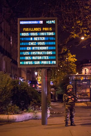 Foto de FRANCIA, París: Soldados franceses aseguran las calles del distrito 11 de París, cerca de la plaza Nation y el bulevar Voltaire, el 14 de noviembre de 2015, pocas horas después de los ataques terroristas en la capital francesa. - Imagen libre de derechos