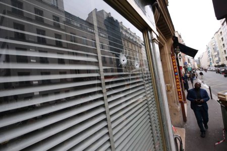 Téléchargez les photos : FRANCE, Paris : Une vitrine d'une pâtisserie dans la rue de Charonne, dans le 11ème arrondissement de Paris, a été endommagée par des balles le 14 novembre 2015 - en image libre de droit