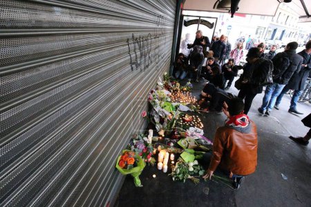 Photo for FRANCE, Paris: People place flowers and candles outside the cafe 'La Belle Equipe' on the Rue de Charonne, in the 11th arrondissement of Paris, on November 14, 2015 - Royalty Free Image