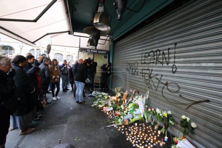 Téléchargez les photos : FRANCE, Paris : Les gens placent fleurs et bougies devant le café "La Belle Equipe" rue de Charonne, dans le 11ème arrondissement de Paris, le 14 novembre 2015 - en image libre de droit