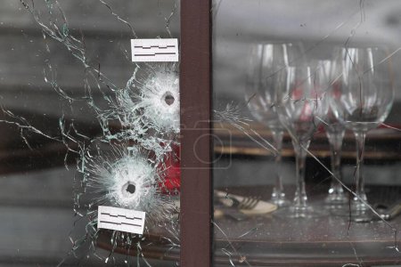 Foto de FRANCIA, París: Los agujeros de bala y las marcas se ven en las ventanas de un café el 14 de noviembre de 2015 en París, Francia. - Imagen libre de derechos