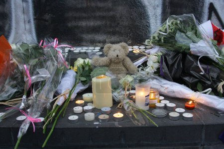 Foto de FRANCIA, París: Flores y notas de apoyo se ven en la calle cerca de la sala de conciertos de Bataclan el 15 de noviembre de 2015, dos días después de los ataques que mataron a más de 130 personas en París. - Imagen libre de derechos