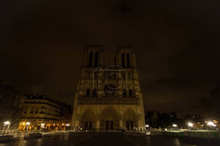 Foto de FRANCIA, París: La catedral de Notre-Dame se representa en la oscuridad en las primeras horas del 16 de noviembre de 2015 después de que las luces del icónico edificio de París se apagaron a raíz de los ataques terroristas mortales. - Imagen libre de derechos