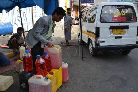 Foto de YEMEN, Sanaa: Un distribuidor del mercado negro vende botellas de gasolina en Sanaa, la capital de Yemen, el 7 de noviembre de 2015, ya que las gasolineras han cerrado desde el comienzo de la guerra y los bombardeos saudíes sobre el país - Imagen libre de derechos