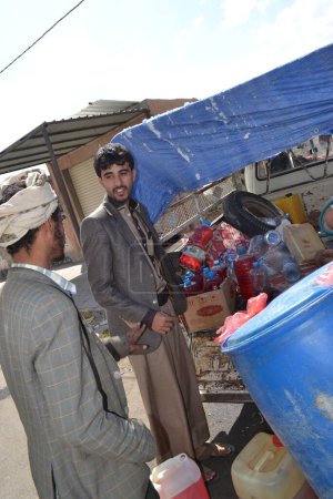 Photo for YEMEN, Sanaa: A black market dealer sells bottles of petrol in Sanaa, Yemen's capital, on November 7, 2015, as petrol stations have closed since the beginning of the war and Saudi bombings over the country - Royalty Free Image