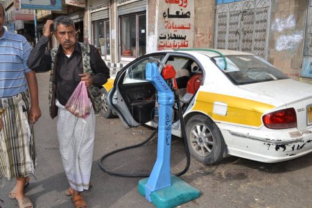 Foto de YEMEN, Sanaa: Un distribuidor del mercado negro vende botellas de gasolina en Sanaa, la capital de Yemen, el 7 de noviembre de 2015, ya que las gasolineras han cerrado desde el comienzo de la guerra y los bombardeos saudíes sobre el país - Imagen libre de derechos
