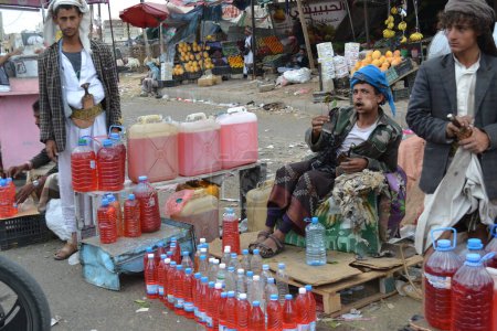 Photo for YEMEN, Sanaa: A black market dealer sells bottles of petrol in Sanaa, Yemen's capital, on November 7, 2015, as petrol stations have closed since the beginning of the war and Saudi bombings over the country - Royalty Free Image