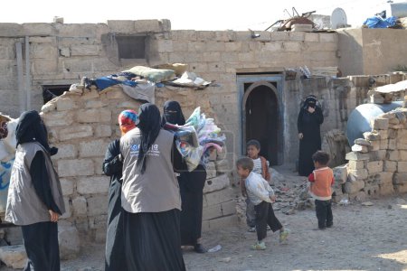 Foto de YEMEN, Sanaa: Miembros de la organización humanitaria local Mona Relief distribuyen ropa a familias desplazadas y personas pobres cerca de Sanaa, la capital de Yemen, el 11 de noviembre de 2015. - Imagen libre de derechos