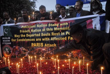 Foto de PAKISTÁN, Islamabad: Un hombre enciende velas durante una vigilia de velas afuera del Club de Prensa en Islamabad, Pakistán, el 16 de noviembre de 2015, en honor a las 129 víctimas de los ataques terroristas del viernes en París - Imagen libre de derechos