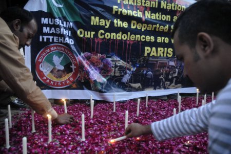 Foto de PAKISTÁN, Islamabad: Un hombre enciende velas durante una vigilia de velas afuera del Club de Prensa en Islamabad, Pakistán, el 16 de noviembre de 2015, en honor a las 129 víctimas de los ataques terroristas del viernes en París - Imagen libre de derechos