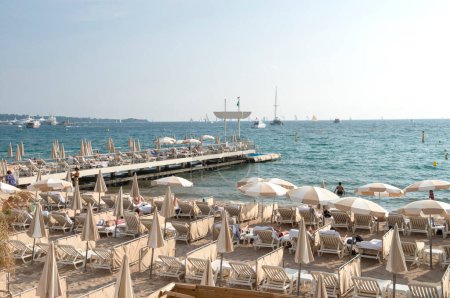 Téléchargez les photos : Cannes, France - 6 mai 2013 : Les gens sur la plage de Cannes. La célèbre plage de la Croisette, connue pour son festival de cinéma. Les gens se baignent au soleil, nagent et se reposent 8 mois dans l'année
. - en image libre de droit