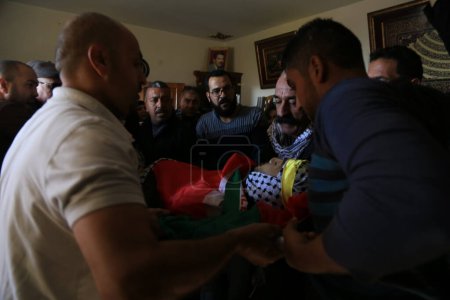 Photo for WEST BANK, Anata: The body of Mahmoud Sa'ed Illean, a 22-year-old Palestinian man, is carried during his funeral at his family's home in Anata, West Bank on November 20, 2015. - Royalty Free Image