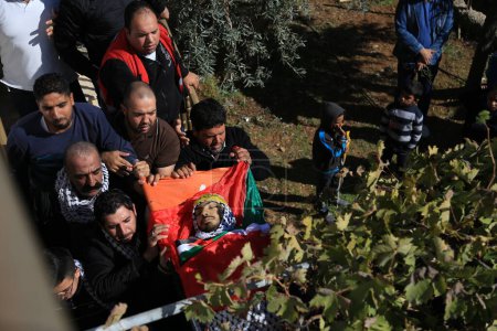 Téléchargez les photos : BANQUE DE L'OUEST, Anata : Le corps de Mahmoud Sa'ed Illean, un Palestinien de 22 ans, est porté lors de ses funérailles au domicile de sa famille à Anata, en Cisjordanie, le 20 novembre 2015. - en image libre de droit