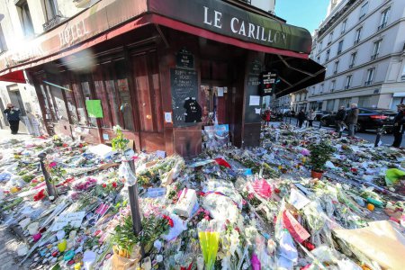 Photo for FRANCE, Paris: Flowers and candles are shown near La belle Equipe cafe on November 21, 2015 in Paris. This cafe is one of the places attacked by terrorists in Paris on November 13, 2015. - Royalty Free Image