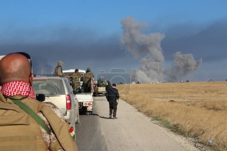 Téléchargez les photos : IRAQ, Sinjar : Les forces peshmergas, soutenues par des véhicules blindés et des milliers de volontaires de tout le gouvernorat régional du Kurdistan se rassemblent le long de la route avant la poussée finale vers Sinjar, le 12 novembre 2015. - en image libre de droit