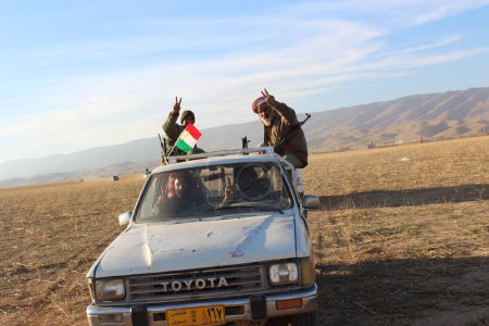 Téléchargez les photos : IRAQ, Sinjar : Les forces peshmergas, soutenues par des véhicules blindés et des milliers de volontaires de tout le gouvernorat régional du Kurdistan se rassemblent le long de la route avant la poussée finale vers Sinjar, le 12 novembre 2015. - en image libre de droit