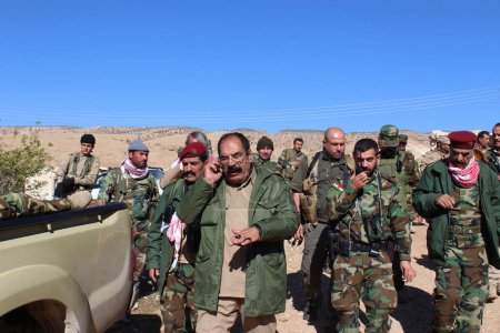 Téléchargez les photos : IRAQ, Sinjar : Un commandant des Peshmergas est au téléphone après la reprise de Sinjar par les forces peshmergas, soutenu par des véhicules blindés et des milliers de volontaires de tout le gouvernement régional du Kurdistan, le 13 novembre 2015. - en image libre de droit