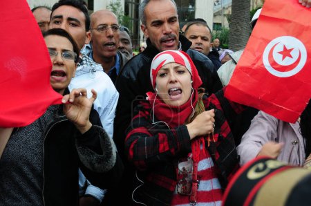 Téléchargez les photos : TUNISIE, Tunis : Des dizaines de personnes se rassemblent dans l'avenue Mohammed V, dans le centre de Tunis, en Tunisie, chantant contre le terrorisme le 25 novembre 2015, un jour après qu'au moins 13 personnes soient mortes dans l'explosion d'un bus de la garde présidentielle. - en image libre de droit