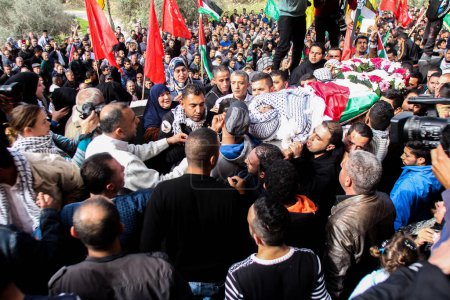 Téléchargez les photos : BANQUE DE L'OUEST, Ramallah : Des agents de sécurité palestiniens portent le corps d'Ibrahim Dawood, 16 ans, lors de ses funérailles à Ramallah, en Cisjordanie, le 26 novembre 2015. - en image libre de droit