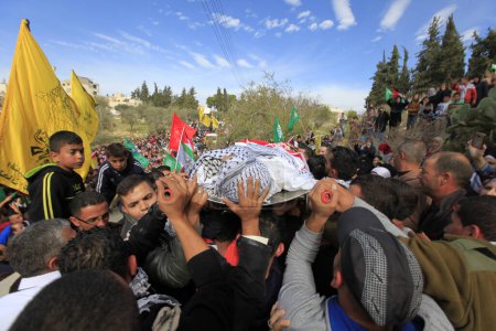 Photo for WEST BANK, Ramallah : Palestinian security officers carry the body of 16-year-old Ibrahim Dawood during his funeral in the West Bank city of Ramallah on November 26, 2015. - Royalty Free Image