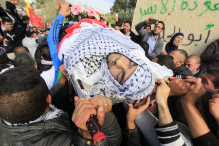 Téléchargez les photos : BANQUE DE L'OUEST, Ramallah : Des agents de sécurité palestiniens portent le corps d'Ibrahim Dawood, 16 ans, lors de ses funérailles à Ramallah, en Cisjordanie, le 26 novembre 2015. - en image libre de droit