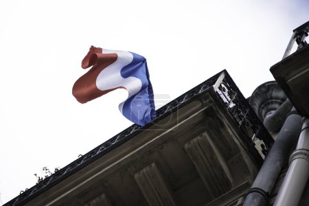 Téléchargez les photos : FRANCE, Paris : Un résident a pendu un drapeau de la France à Paris le 26 novembre 2015 en hommage aux victimes d'attentats terroristes décédées le 13 novembre 2015 - en image libre de droit