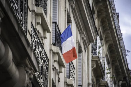 Téléchargez les photos : FRANCE, Paris : Un résident a pendu un drapeau de la France à Paris le 26 novembre 2015 en hommage aux victimes d'attentats terroristes décédées le 13 novembre 2015 - en image libre de droit